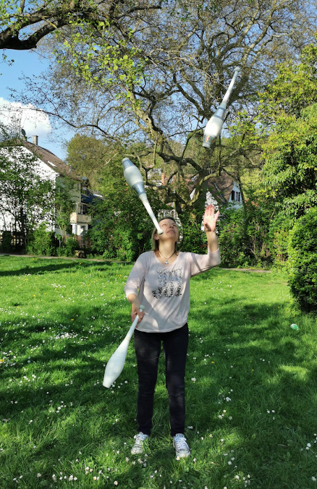 Jonglieren mit 3 Keulen auf Wiese